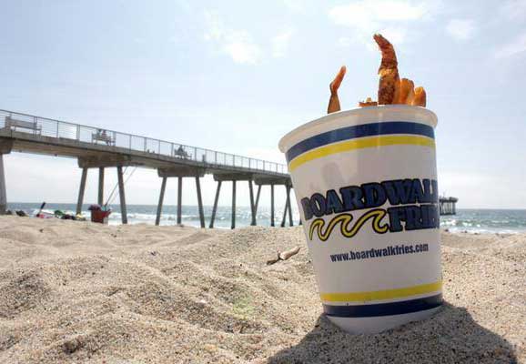 A bucket of fries on the beach.